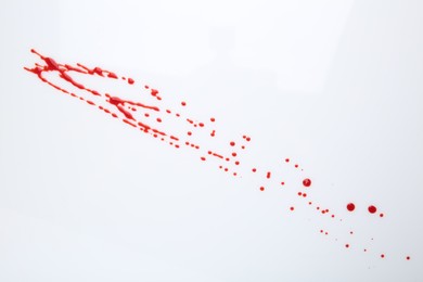 Photo of Splashes of red blood on white background