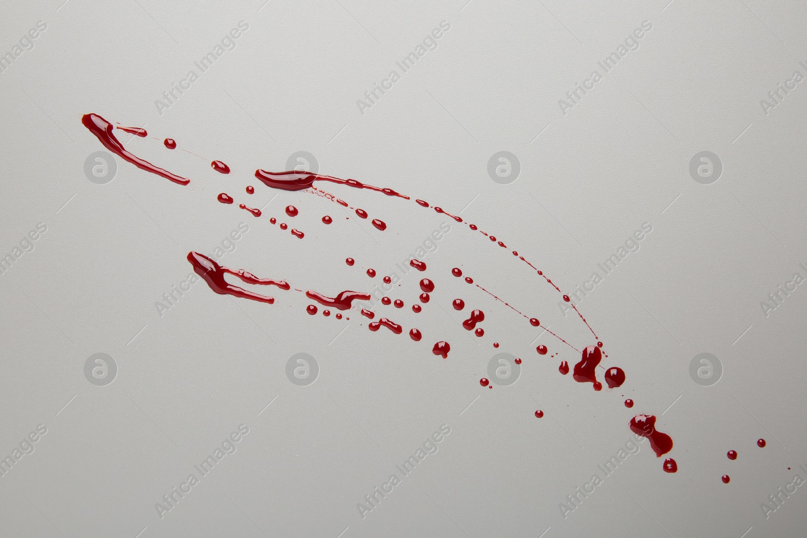 Photo of Splashes of red blood on light background