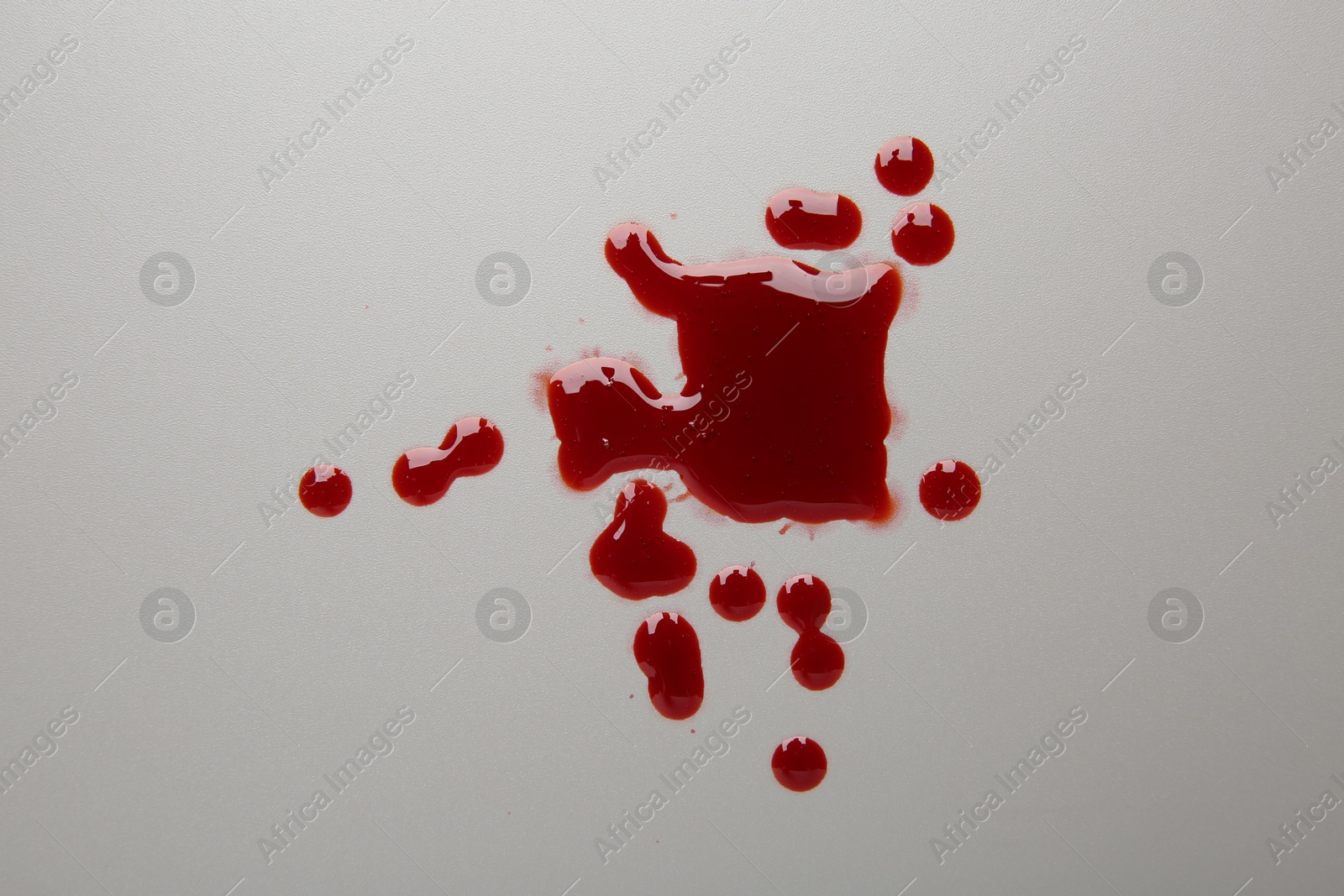 Photo of Drops of red blood on light background