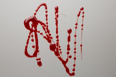 Photo of Splashes of red blood on light background