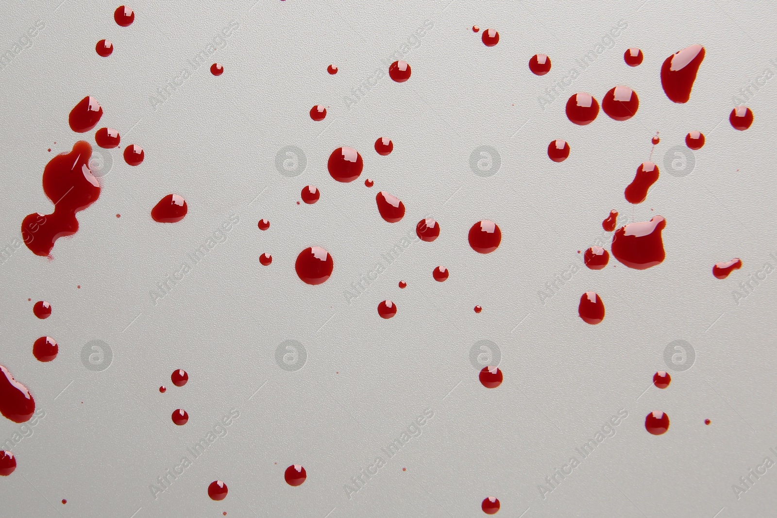 Photo of Drops of red blood on light background