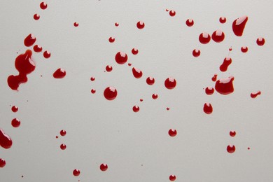 Photo of Drops of red blood on light background