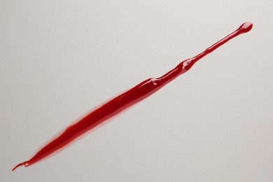 Photo of Splash of red blood on light background