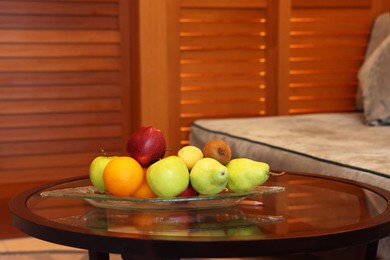 Different fresh fruits on glass table in hotel room