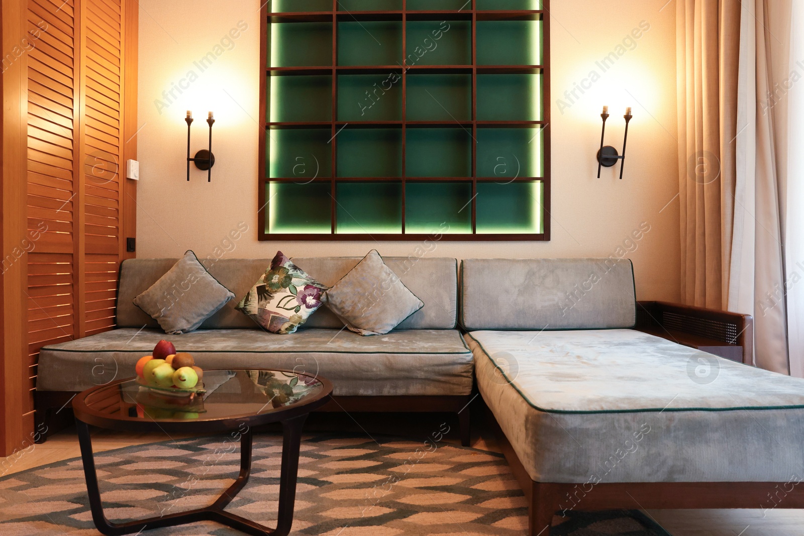 Photo of Comfortable sofa with cushions and table in hotel room