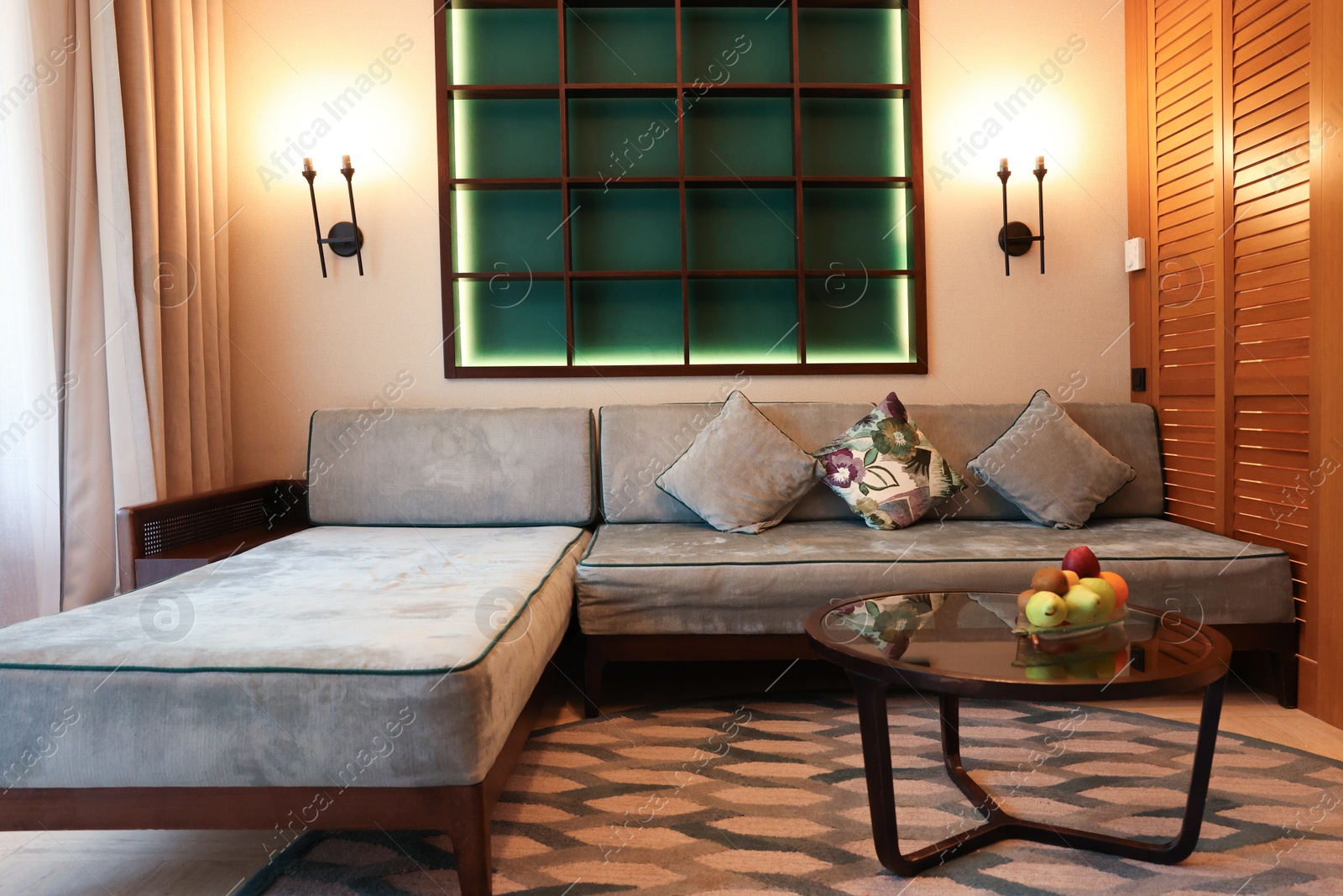 Photo of Comfortable sofa with cushions and table in hotel room