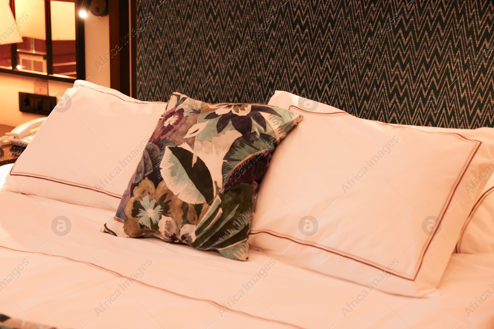 Photo of Comfortable bed with soft pillows in hotel room