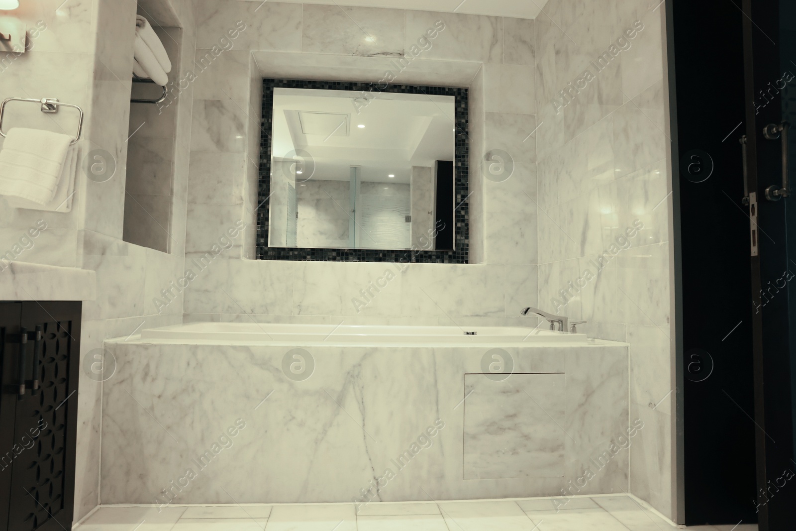 Photo of Stylish bathroom with marble bathtub and mirror in luxury hotel