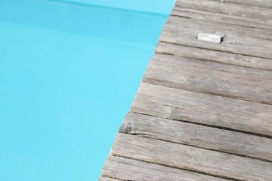 Photo of Wooden desk near outdoor swimming pool at resort