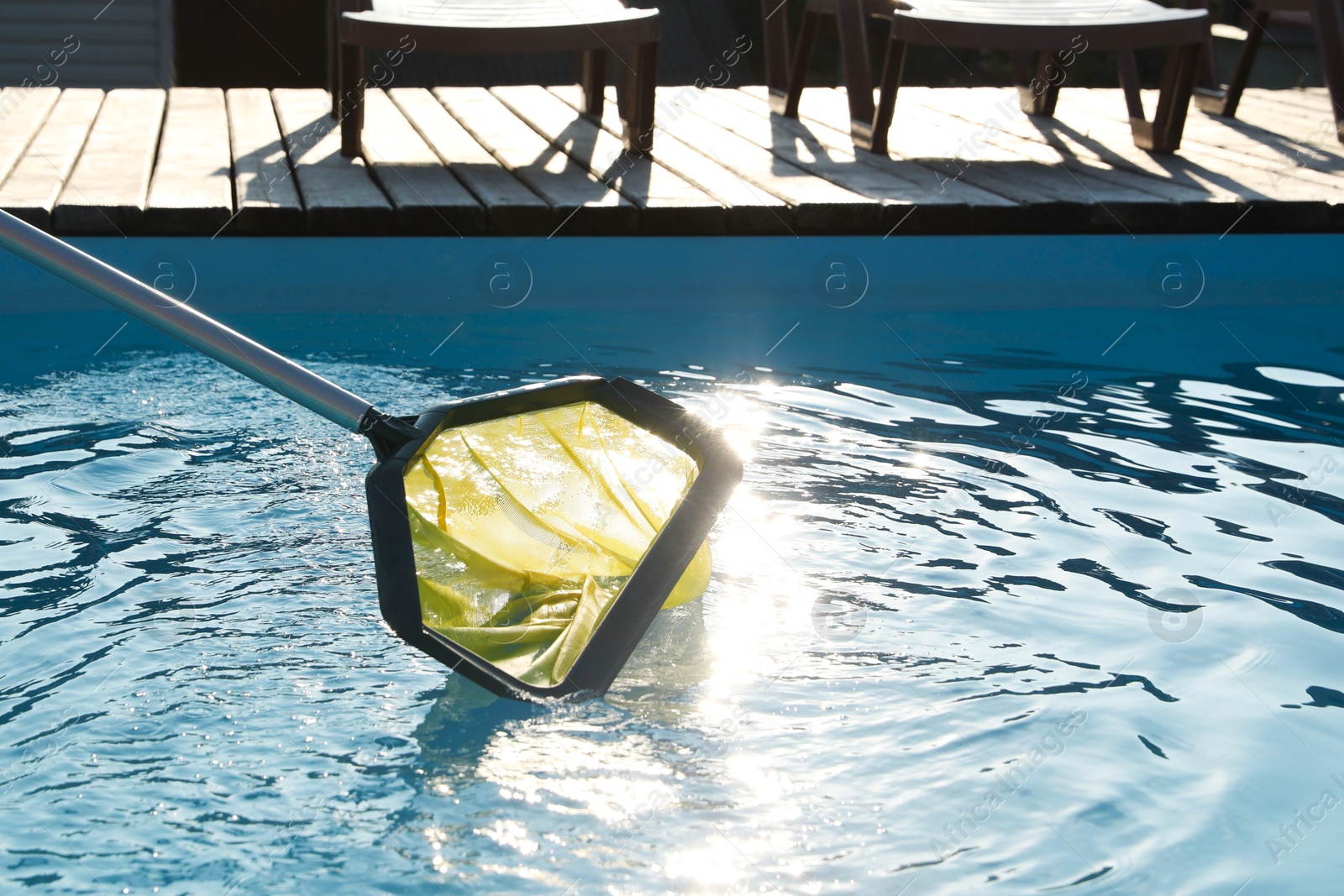 Photo of Cleaning swimming pool with skimmer net at luxury resort