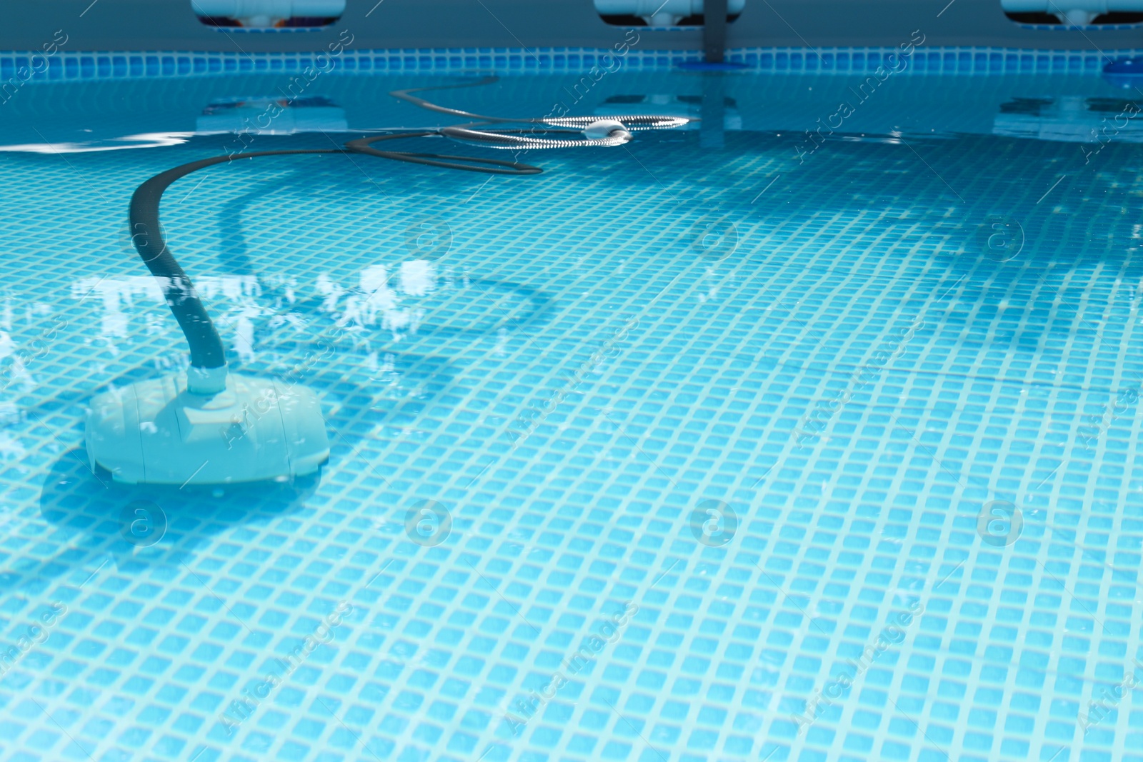 Photo of One robotic cleaner in swimming pool outdoors, space for text