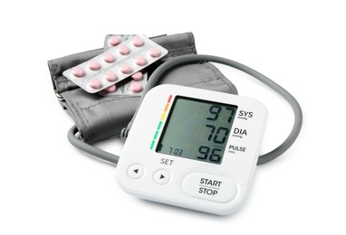 Photo of Blood pressure measuring device and pill blisters isolated on white