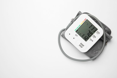 Blood pressure measuring device on light grey background, top view. Space for text