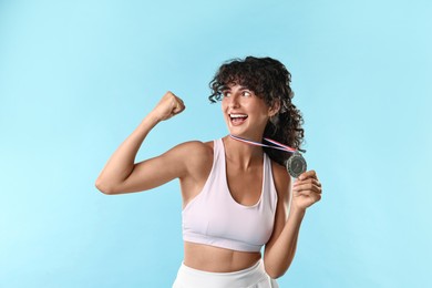 Photo of Happy winner with silver medal on light blue background