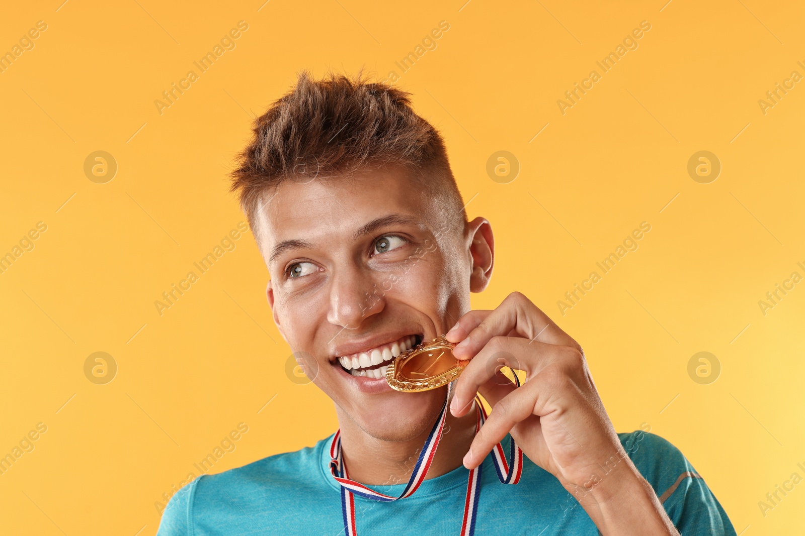 Photo of Happy winner with golden medal on yellow background