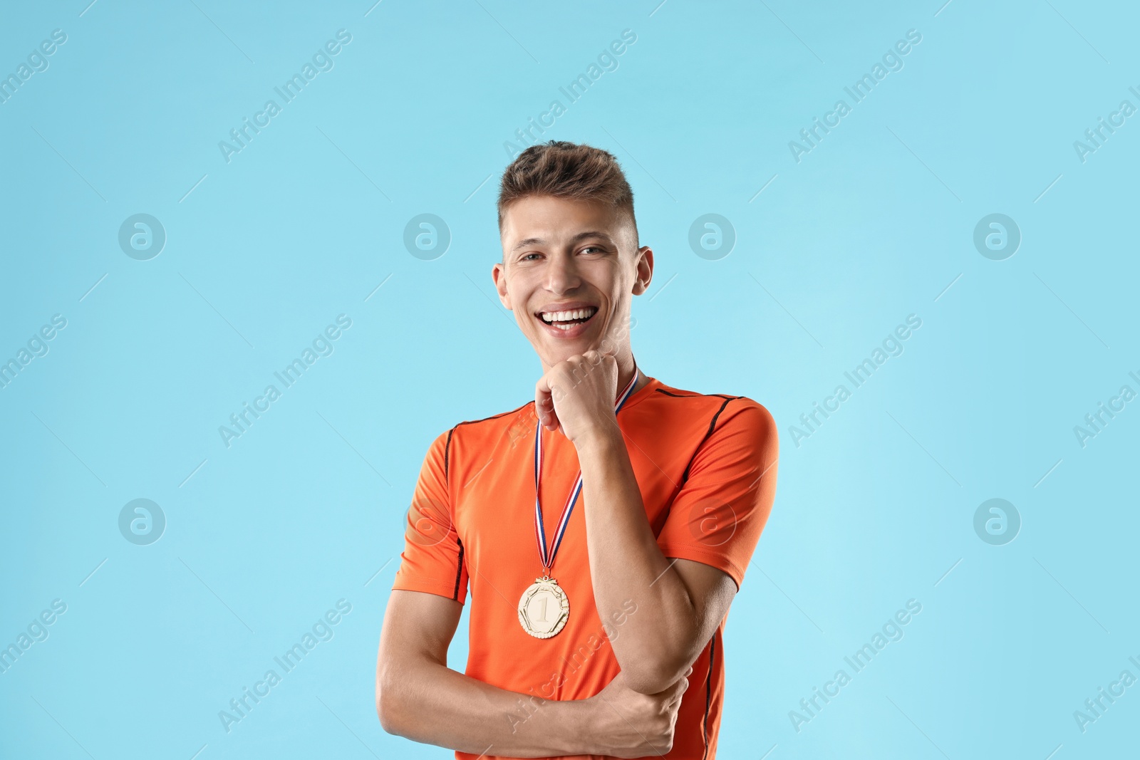 Photo of Happy winner with medal on light blue background