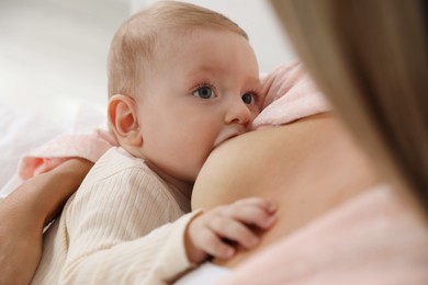 Mother breastfeeding her little baby indoors, closeup