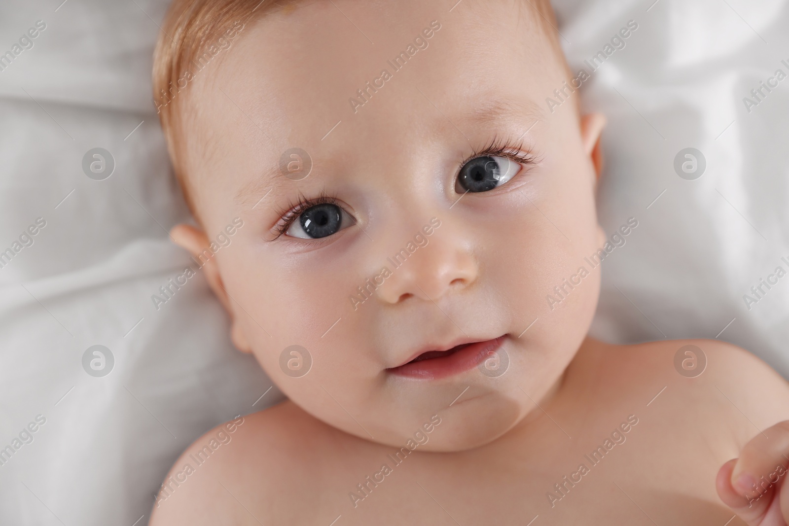 Photo of Cute little baby on bed, top view