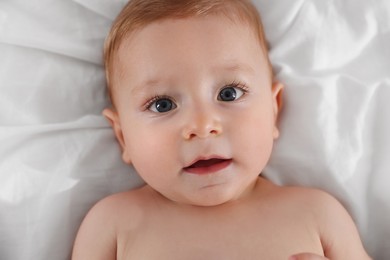 Photo of Cute little baby on bed, top view