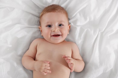 Photo of Cute little baby on bed, top view