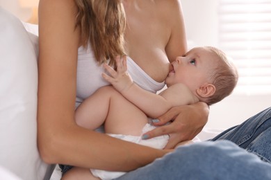 Mother breastfeeding her little baby indoors, closeup