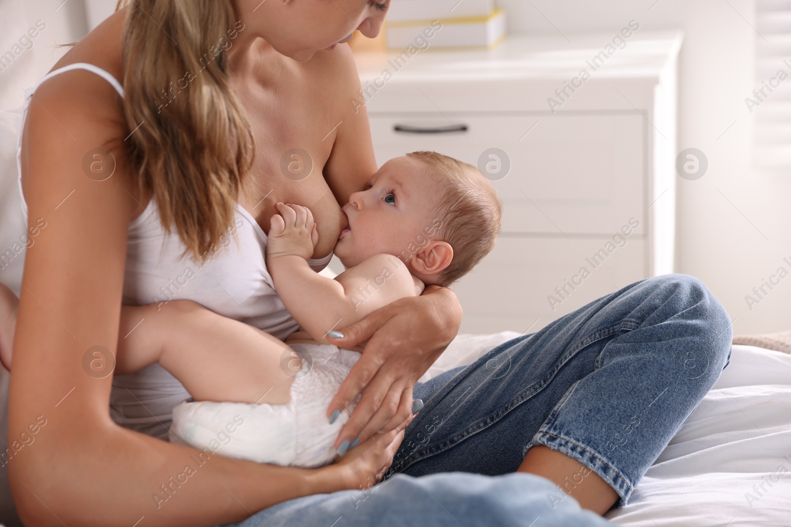 Photo of Mother breastfeeding her little baby indoors, closeup