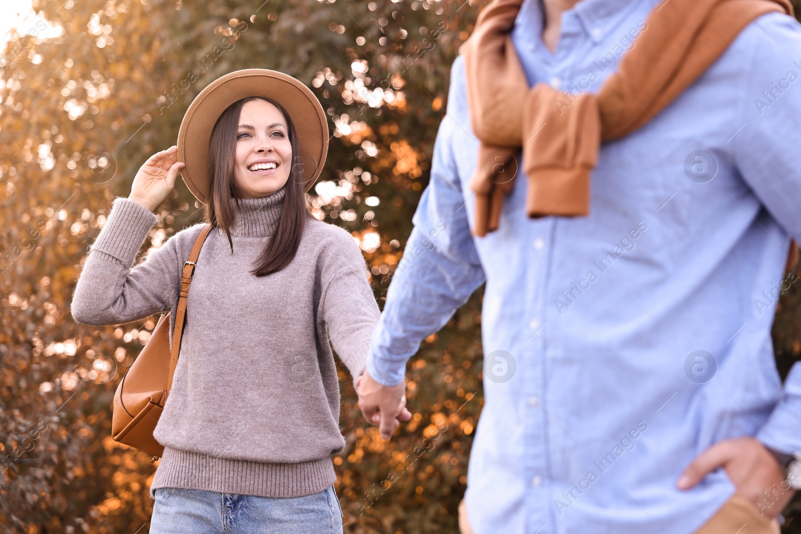 Photo of Beautiful couple walking together in park on autumn day, selective focus