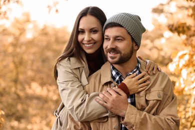 Photo of Beautiful happy couple hugging outdoors on autumn day