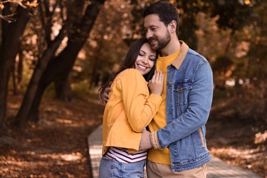 Photo of Beautiful couple hugging in park on autumn day