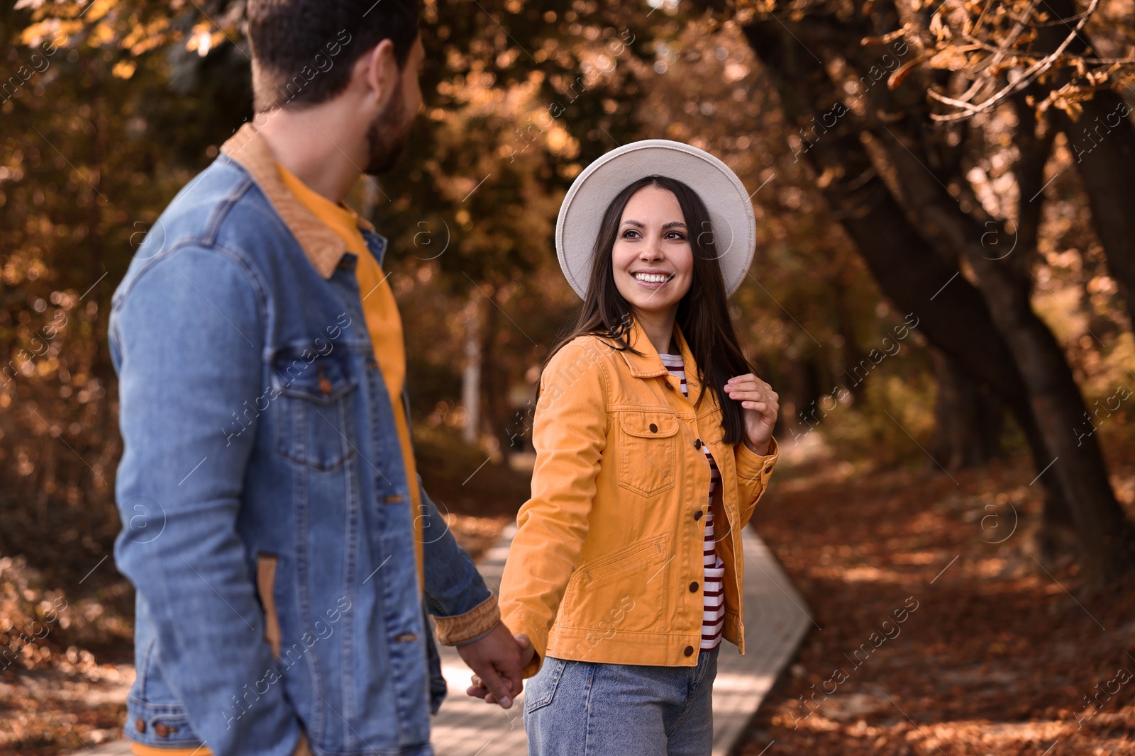 Photo of Beautiful couple walking together in autumn park, selective focus