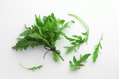 Photo of Fresh green arugula leaves on white background, flat lay