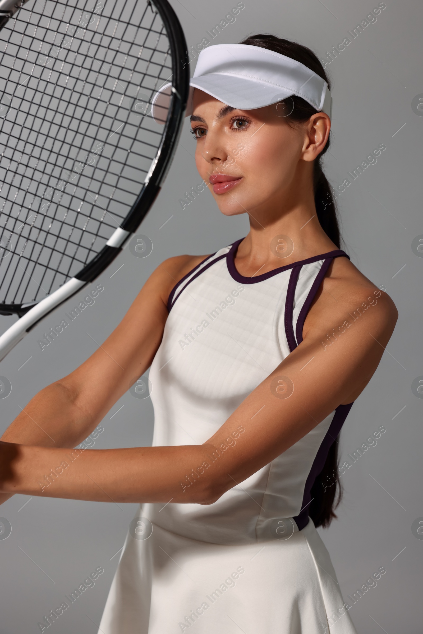 Photo of Tennis player with racket on grey background