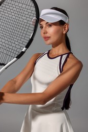 Tennis player with racket on grey background