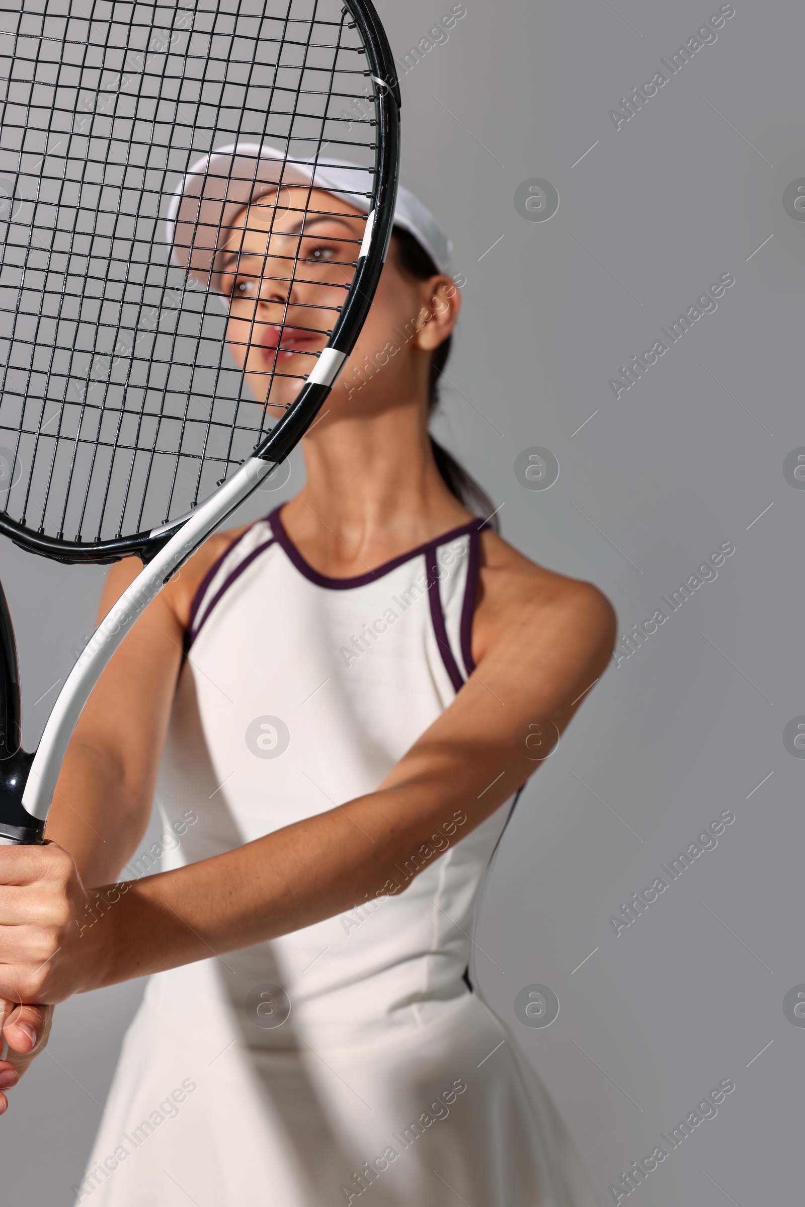 Photo of Tennis player with racket on grey background