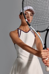 Tennis player with racket on grey background