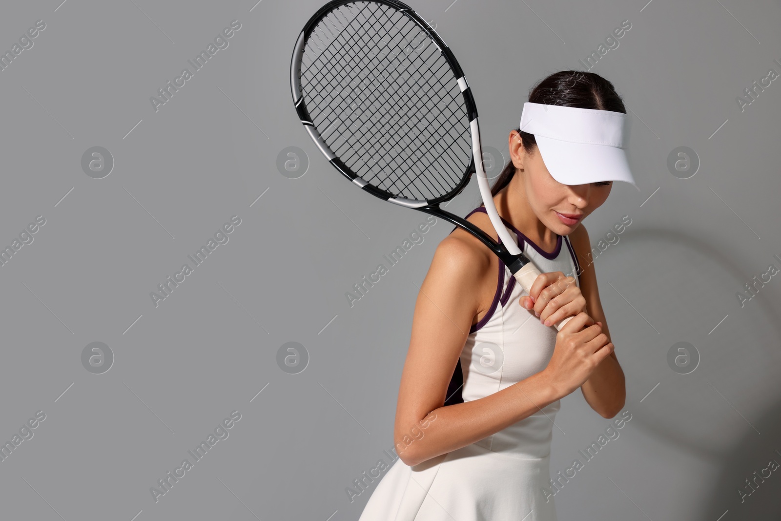 Photo of Tennis player with racket on grey background, space for text