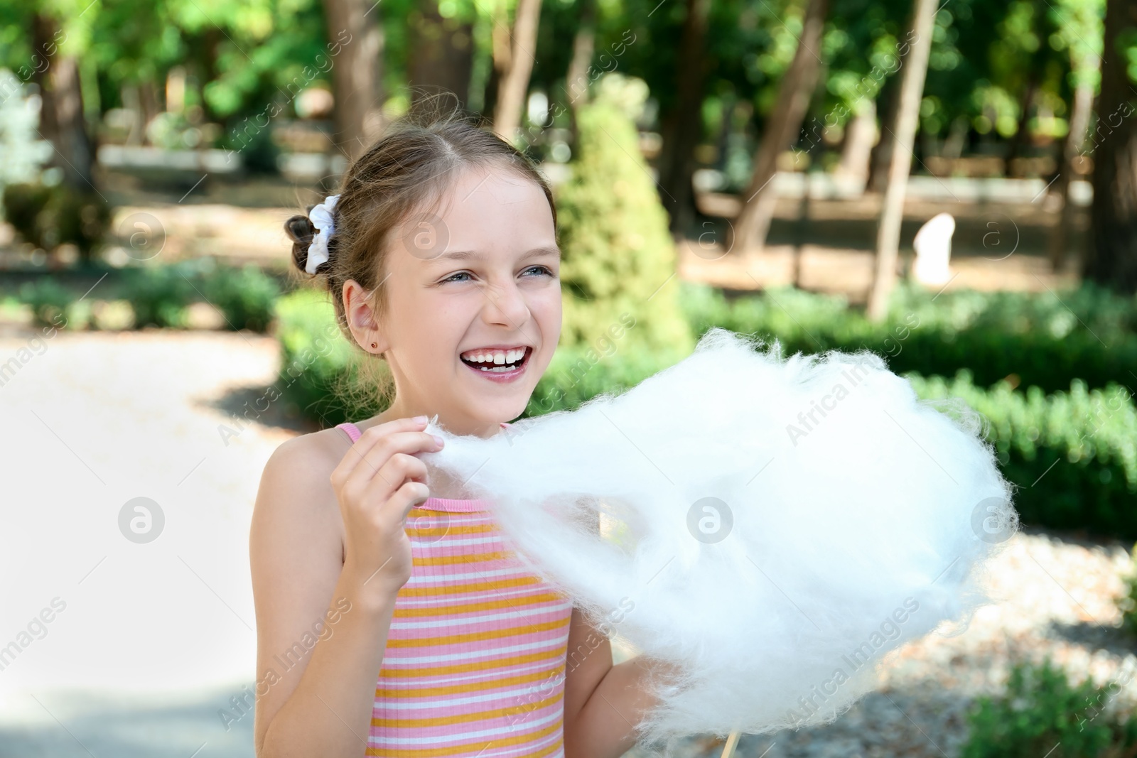 Photo of Portrait of little girl with sweet cotton candy in park