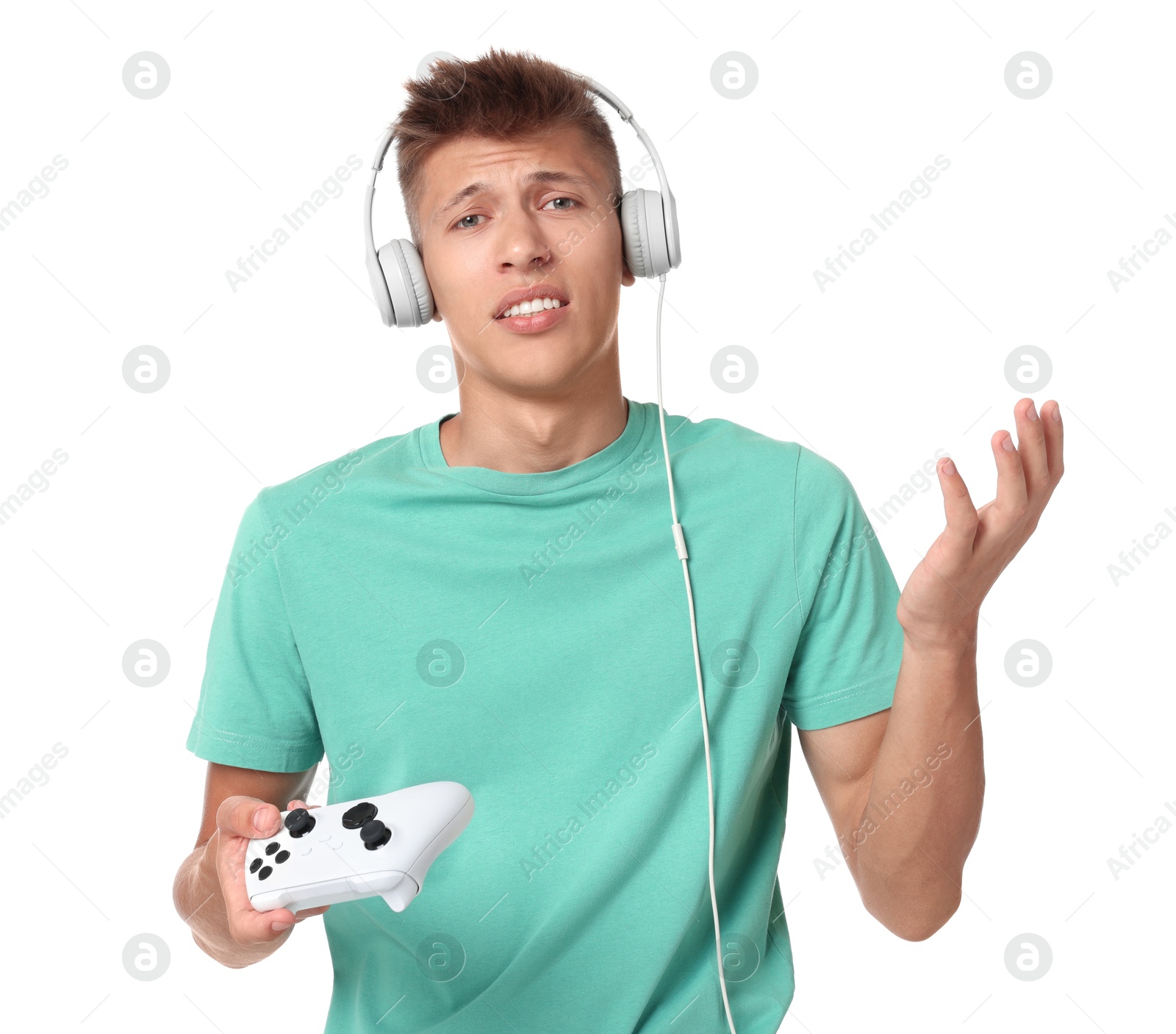 Photo of Unhappy young man in headphones with controller on white background