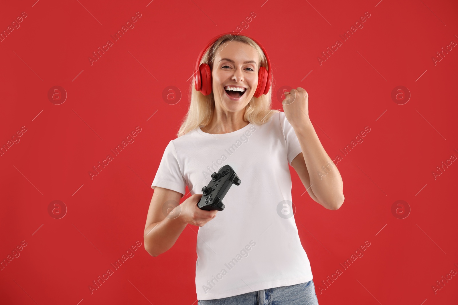 Photo of Happy woman with controller on red background