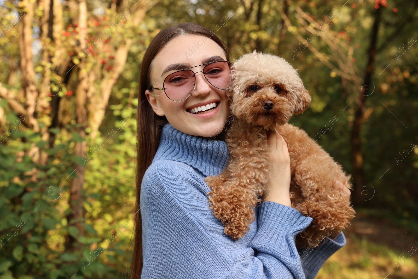 Photo of Smiling woman with cute dog in autumn park