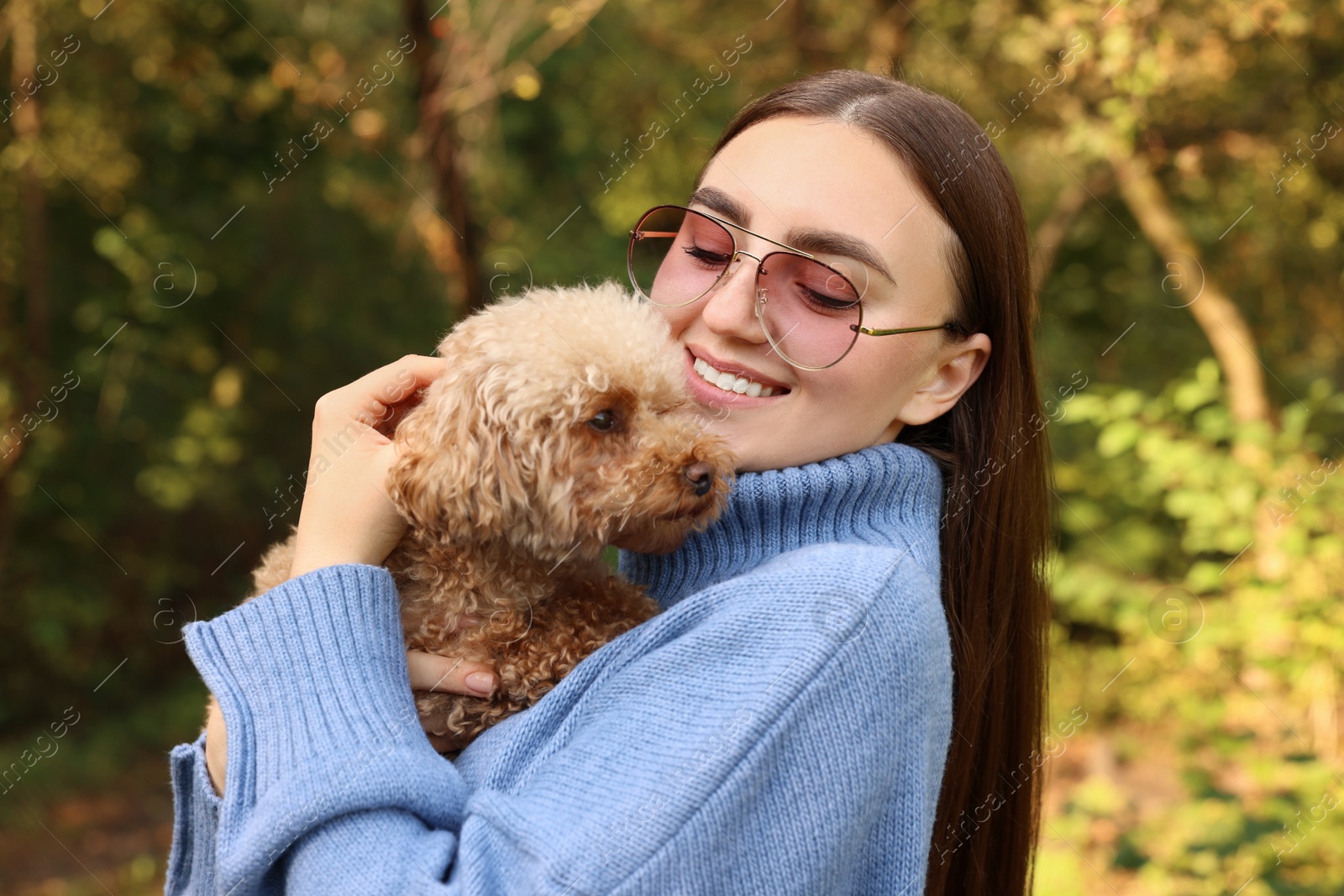 Photo of Smiling woman with cute dog in autumn park