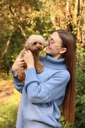 Smiling woman with cute dog in autumn park