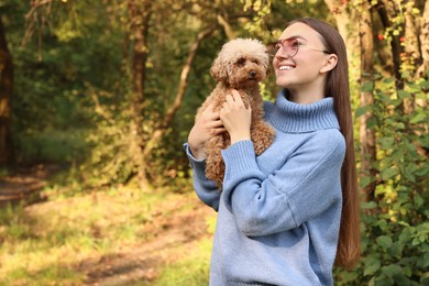 Smiling woman with cute dog in autumn park. Space for text