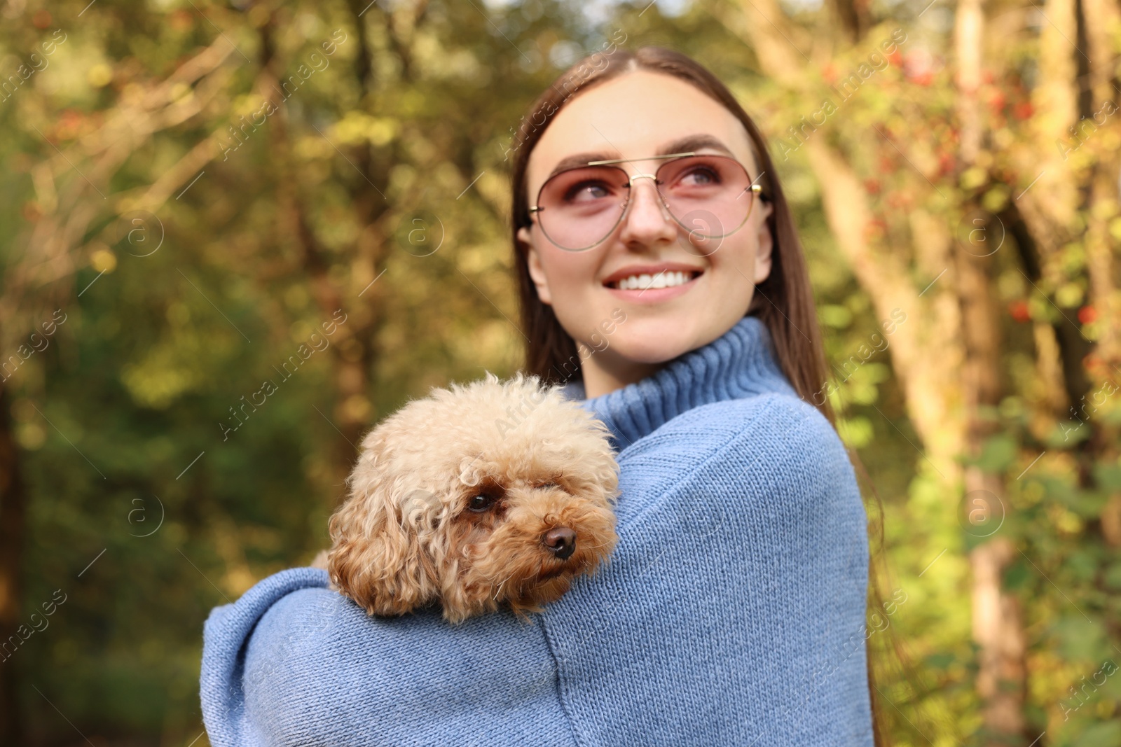 Photo of Smiling woman with cute dog in autumn park