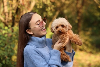 Photo of Smiling woman with cute dog in autumn park