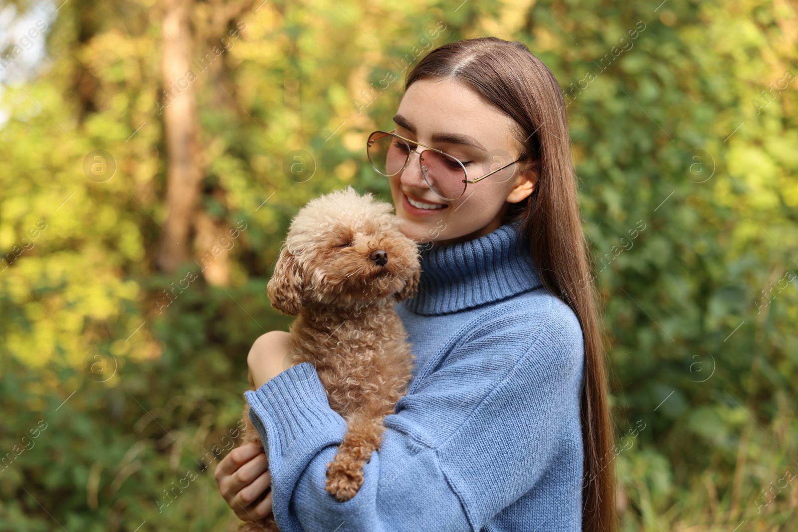 Photo of Smiling woman with cute dog in autumn park