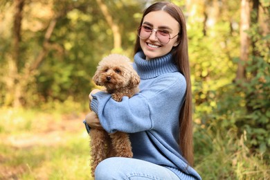 Photo of Smiling woman with cute dog in autumn park