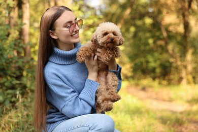 Smiling woman with cute dog in autumn park. Space for text