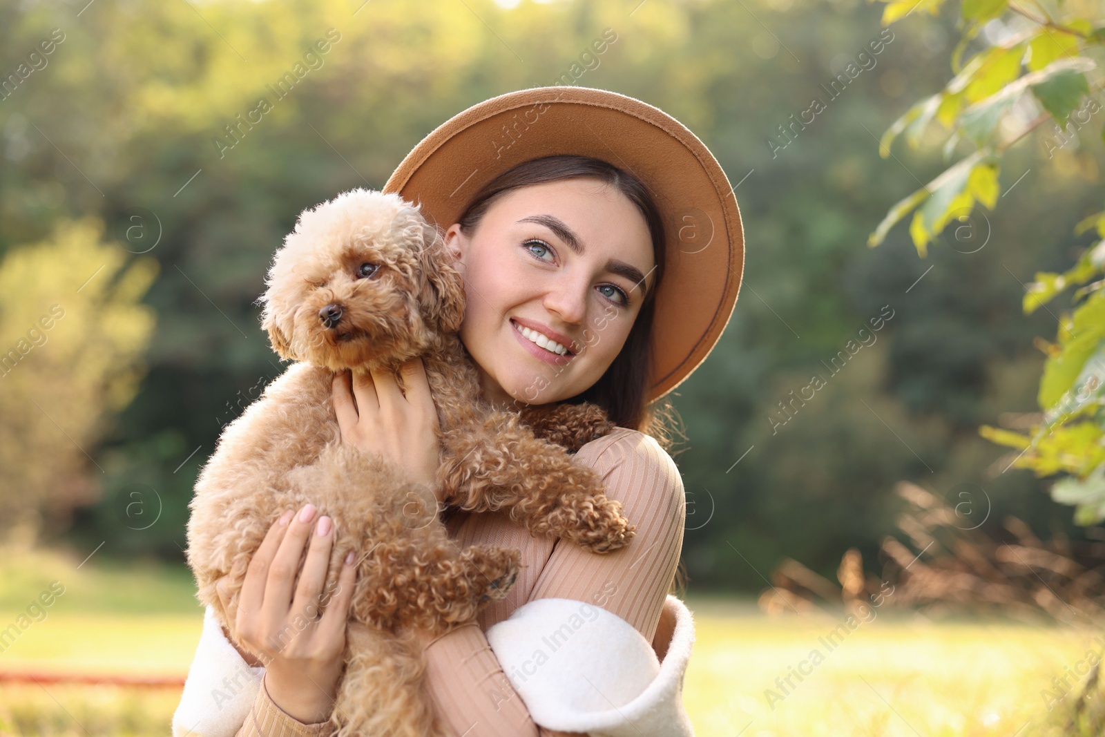 Photo of Smiling woman with cute dog outdoors on sunny day