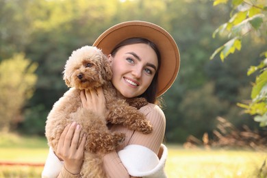 Smiling woman with cute dog outdoors on sunny day